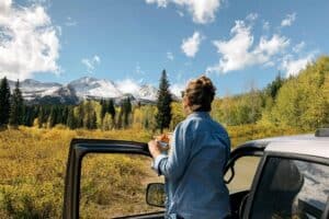 woman standing outside car staring off into distance