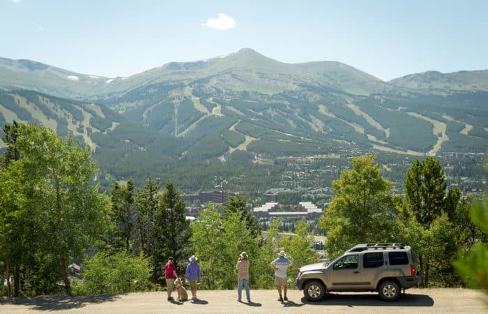 A group of people on Boreas Pass in the summer with Breckenridge Ski Resort in the Background