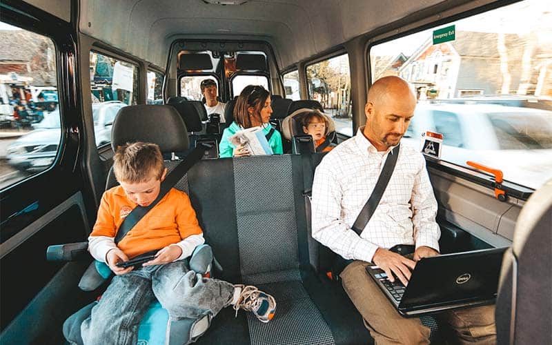 Family riding shuttle while using their devices