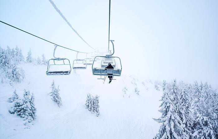 person riding ski lift at resort.