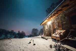 skis outside cabin at night