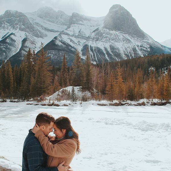 couple kissing in front of mountain