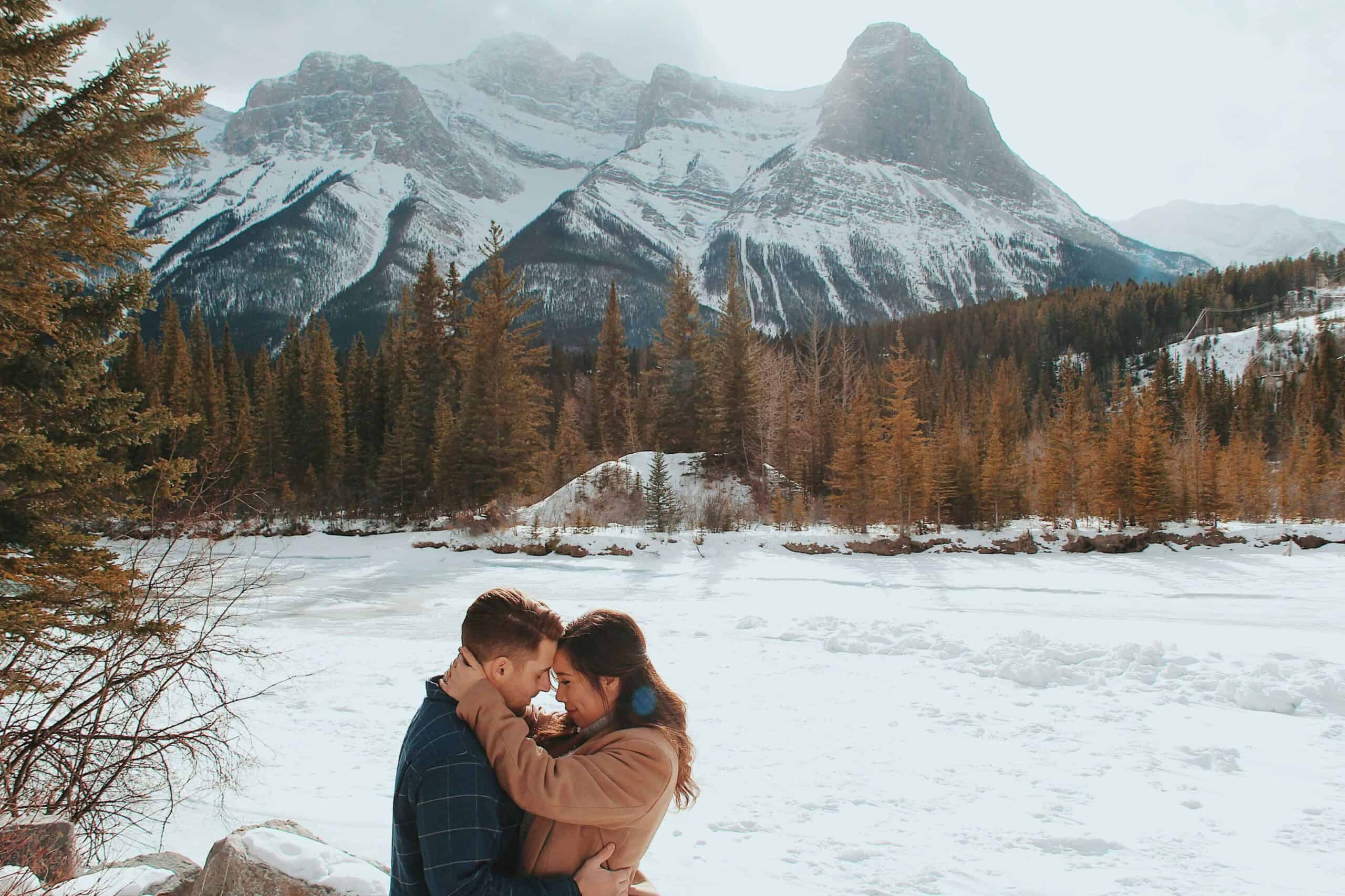 couple kissing in front of mountain